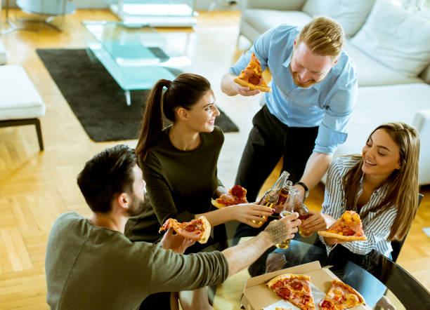 istock Young people eating pizza and drinking cider in the modern interior 1097339280