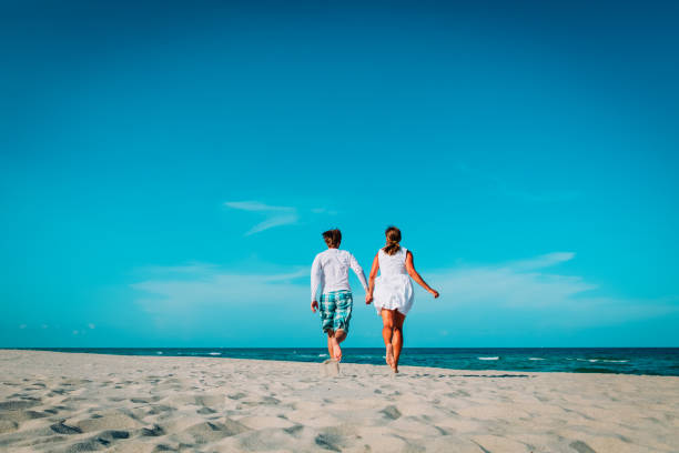 istock happy loving couple run play enjoy tropical beach 1097340048