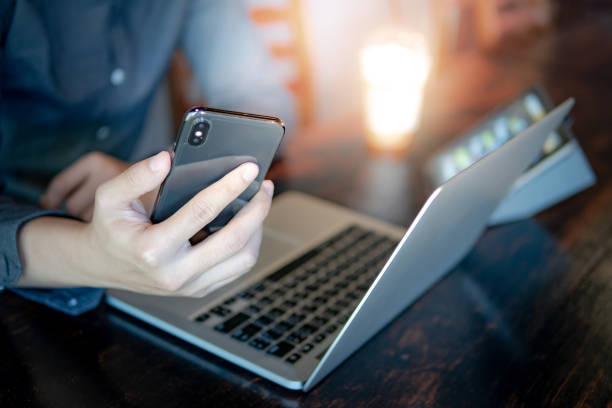 male hand holding smartphone. businessman using laptop computer and digital tablet while working in the cafe. mobile app or internet of things concepts. modern lifestyle in digital age. - internet dating men chat room internet imagens e fotografias de stock