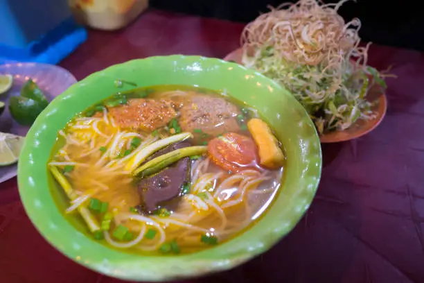 Photo of Beer rich noodle Vietnamese cuisine called Bun Bo Hue. popular Vietnamese soup containing rice vermicelli and beef