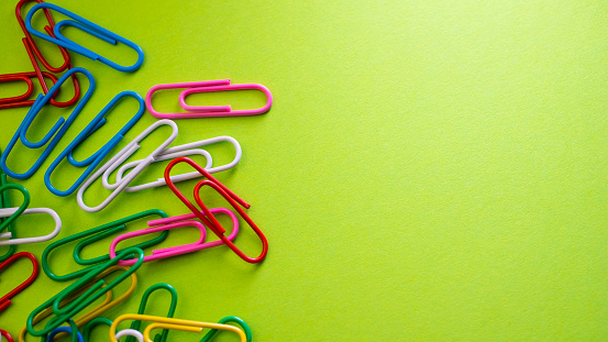 Colorful paper clips on pink background