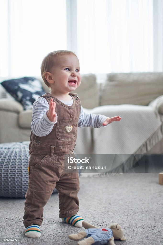 Portrait Of A Cute 1 Year Old Baby Boy Standing On The Floor The First  Steps Concept Stock Photo - Download Image Now - Istock