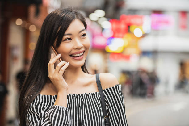 Cheerful Chinese woman on phone smiling