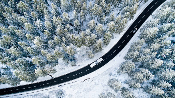 istock Road through the wintery forest - aerial view 1097372528