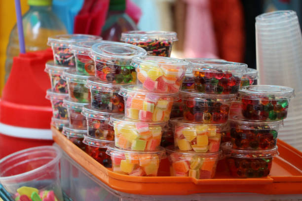 Stack of colorful sweetmeat in the plastic cup for sale.