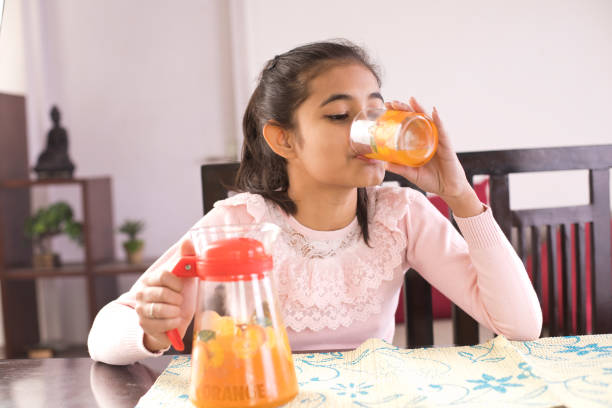 istock Girl drinking orange juice 1097374876
