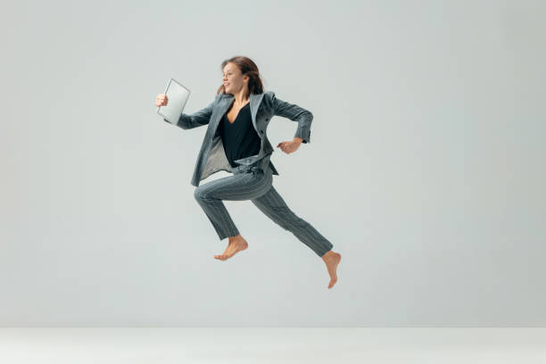 felice donna d'affari che balla e sorride isolata sul bianco. - women action jumping running foto e immagini stock