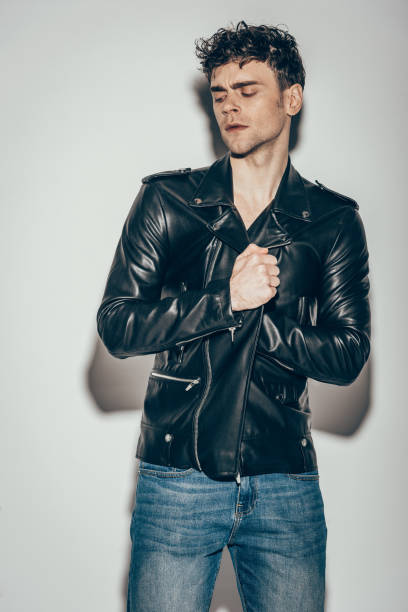 istock handsome sexy man posing in black leather jacket on grey 1097383958