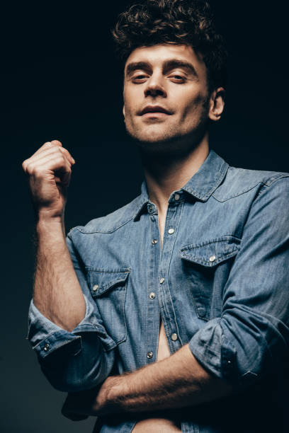 istock handsome smiling man posing in denim clothes isolated on grey 1097385106