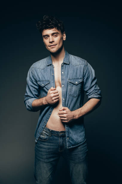 istock handsome muscular man posing in denim clothes isolated on dark grey 1097385242