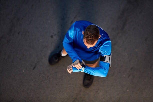 istock Top view of runner standing and watching at wristwatch. 1097386144