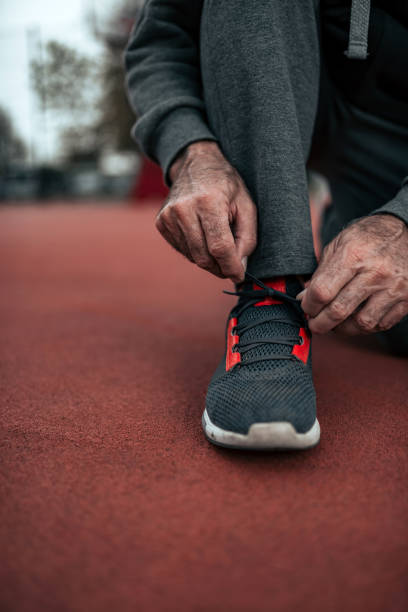 istock Close-up image of senior runner tying shoelace. 1097389788