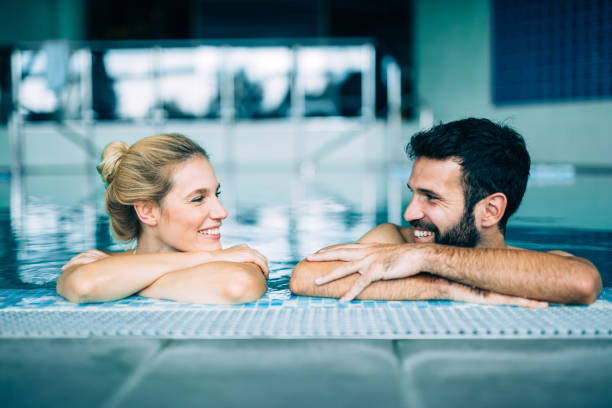 istock Happy attractive couple relaxing in swimming pool 1097394840