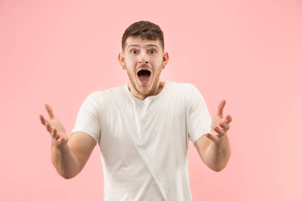 istock The young attractive man looking suprised isolated on pink 1097395092