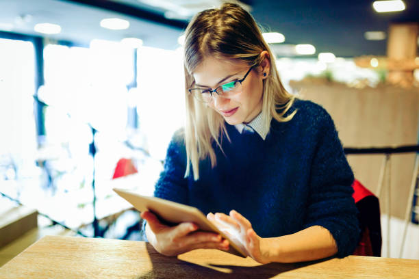 istock Happy young woman drinking coffee and using tablet 1097395660