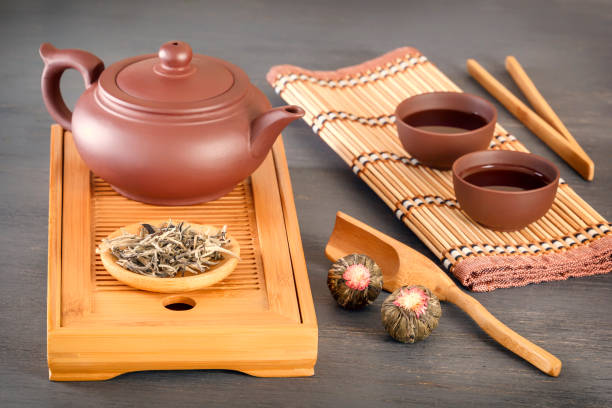 istock green tea and attributes for tea ceremony - a ceramic teapot, cups, a strainer, chopsticks and tweezers are placed on an old wooden table 1097395768