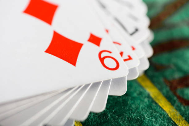 selective focus of playing card with diamonds suit in deck on green poker table