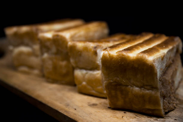 istock Roasted sliced bread with with peanut butter inside. Isolated on black. 1097398180