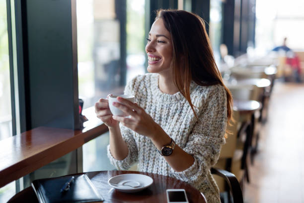 istock Young beautiful woman drinking coffee in restaurant 1097399384