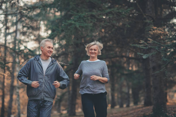 istock Senior couple jogging in a forest 1097399888