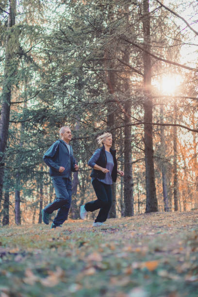 istock Senior couple jogging in a forest 1097400328