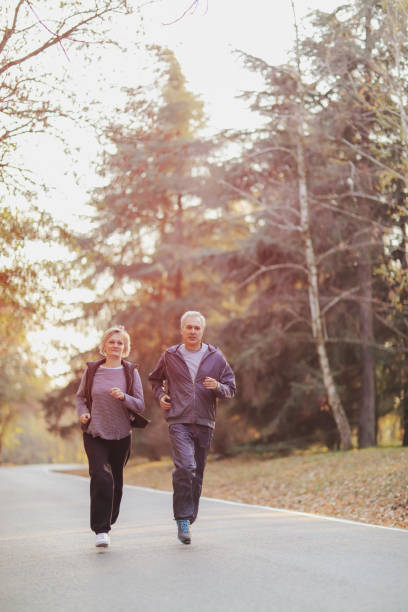 istock Senior couple jogging in a forest 1097401400