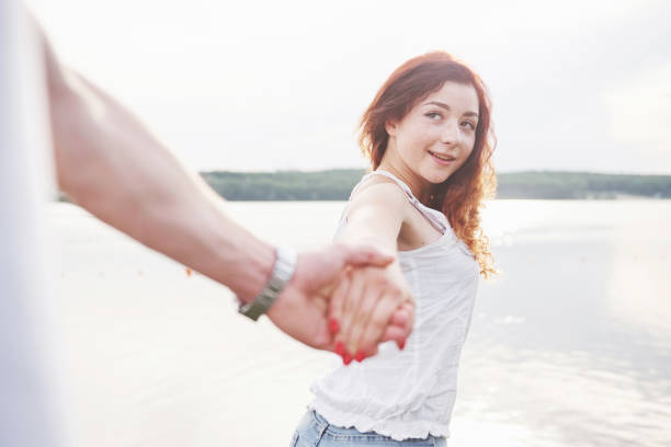 istock A smiling happy woman with a playful expression and a hand with her husband. 1097402814