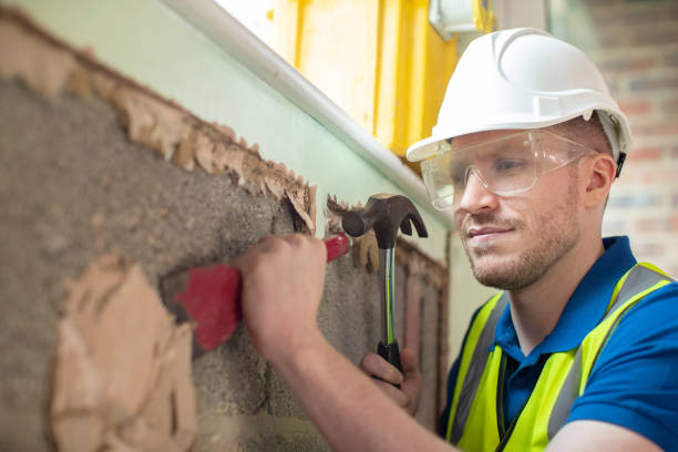 istock Construction Worker With Chisel Removing Plaster From Wall In Renovated House 1097404470