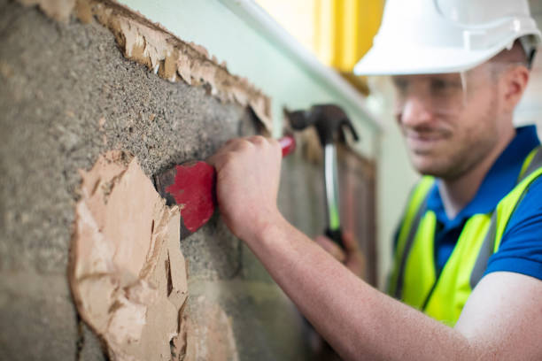 istock Construction Worker With Chisel Removing Plaster From Wall In Renovated House 1097404528