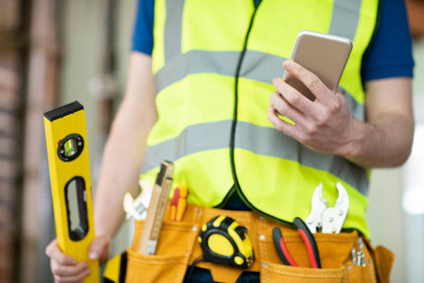 istock Detail Of Construction Worker On Building Site Wearing Tool Belt Using Mobile Phone 1097404646