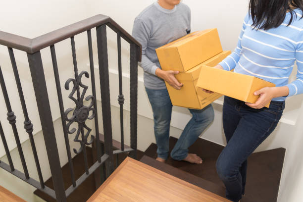 istock Couple holding boxes and walking together - moving house concept 1097405160