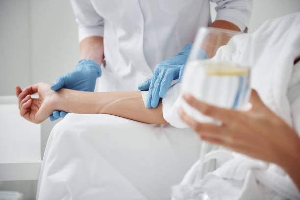 Doctor attaching intravenous drip on lady hand
