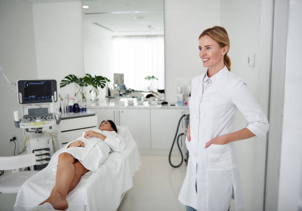 istock Cosmetologist standing and keeping hands in pockets while young lady resting 1097405718