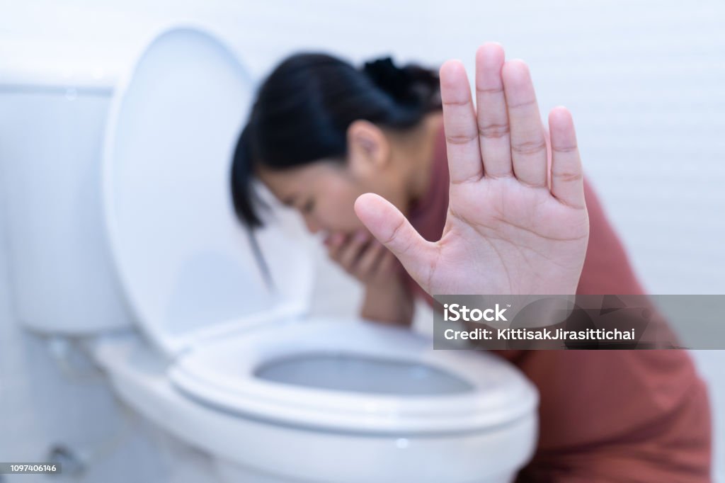 Woman hold hand and vomiting in toilet - sick concept Vomit Stock Photo