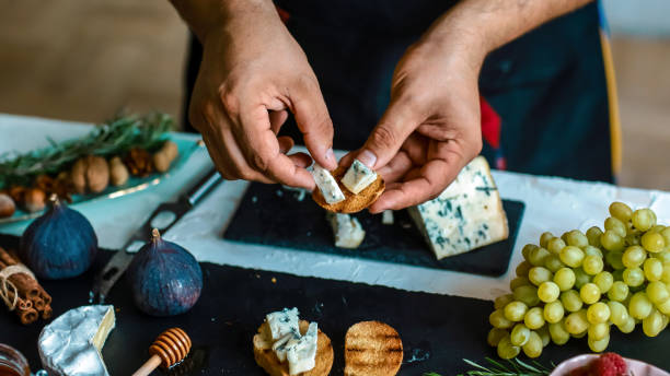 istock Cooking Bruschettas with figs, Blue cheese and walnuts on grilled crusty bread by chef hands on shale board. Food recipe concept 1097406742