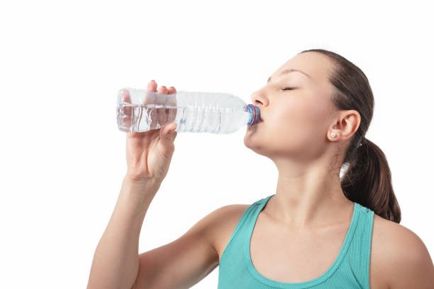 istock Young beautiful woman drinks water from a bottle. 1097408976
