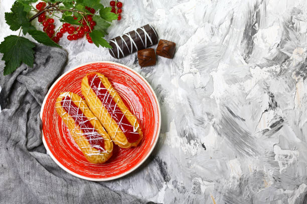 two ecriles with red currant jam on a red plate with fresh currants. Summer fruit dessert. Top view. Free copy space