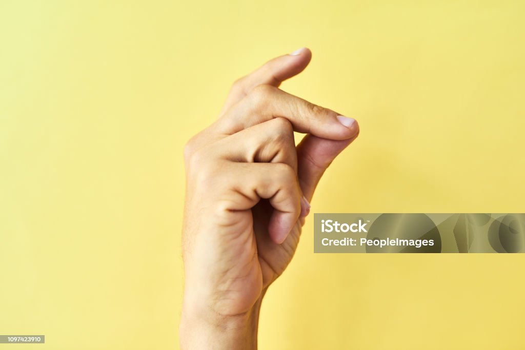 Find your groove Studio shot of an unrecognizable man snapping his fingers against a yellow background Snapping Fingers Stock Photo
