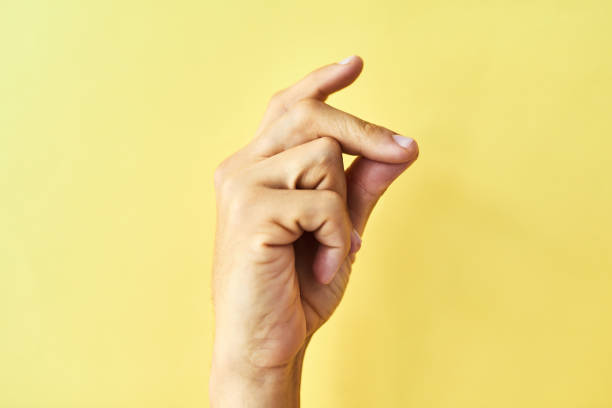 Find your groove Studio shot of an unrecognizable man snapping his fingers against a yellow background click finger stock pictures, royalty-free photos & images