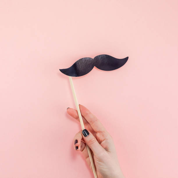 istock Woman hands with black paper moustaches 1097424014