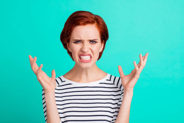 portrait of nice charming attractive mad distracted red-haired lady in striped pullover showing rage gesture isolated over bright vivid shine green turquoise background - beautiful female displeased furious imagens e fotografias de stock