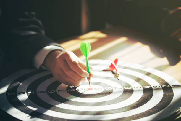 istock businessman holding dart attached to target on dartboard 1097430788