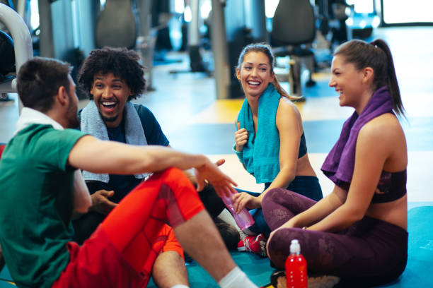 istock Young cheerful people resting from exercising at gym and communicating 1097431330