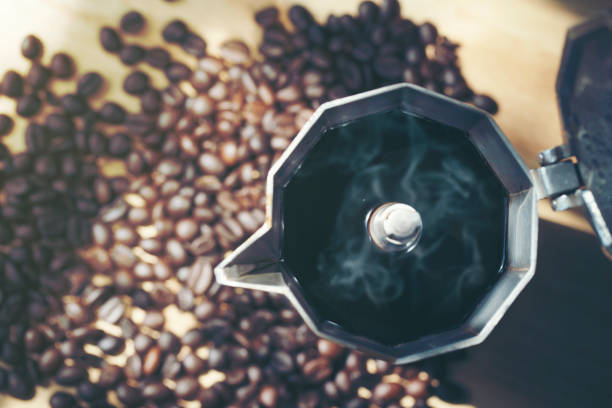 Hot coffee in moka pot with coffee bean,top view