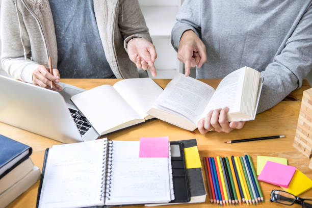 istock High school tutor or college student group sitting at desk in library studying and reading, doing homework and lesson practice preparing exam to entrance, education, teaching, learning concept 1097432224