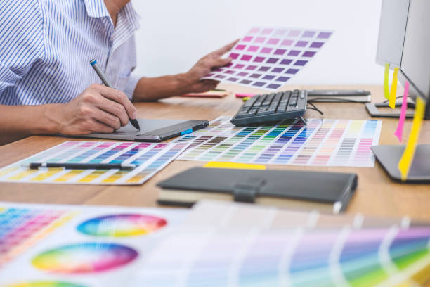 istock Image of male creative graphic designer working on color selection and drawing on graphics tablet at workplace with work tools and accessories in workspace 1097432258