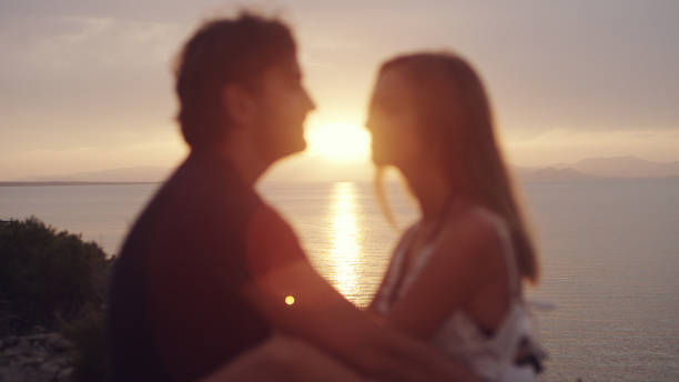 Couple admiring a view from cliff. Hugging and kissing
