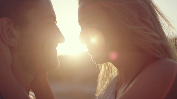 istock Couple cuddled together standing on the beach. Sunset 1097432782