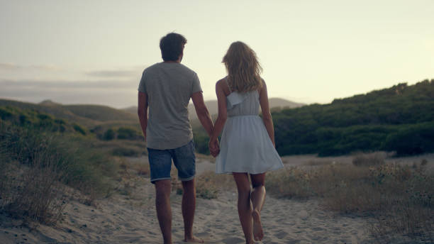 istock Couple walking along the beach. Sunset 1097432840
