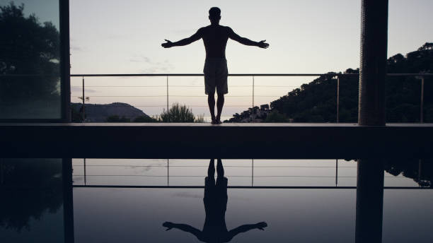 istock Vinyasa flow. Man doing yoga by the pool. Mountain pose 1097435394